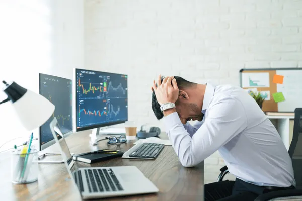 Trader déçu avec les mains au-dessus de sa tête